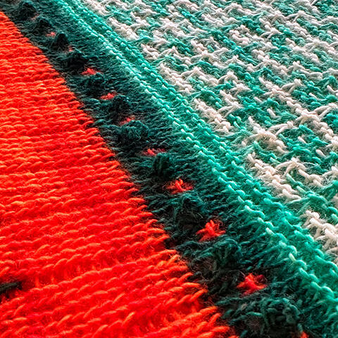 Detalje af Ghost Dancer-sjalets kant – skarpe farvekontraster og tekniske finesser, der giver dit strik et professionelt udtryk. Lær det hele trin for trin på strikkekurset.